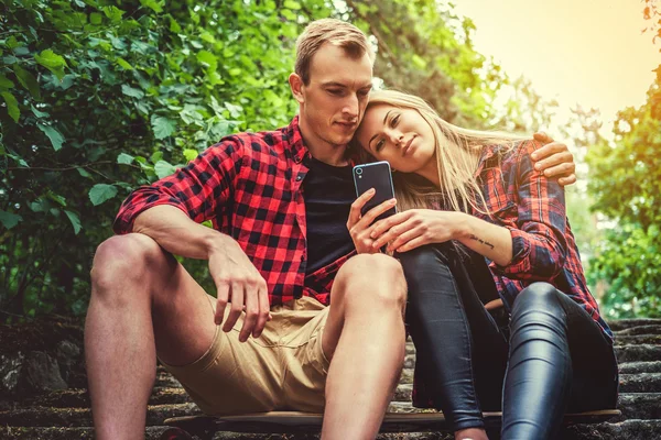 Pareja joven casual relajándose en las escaleras — Foto de Stock