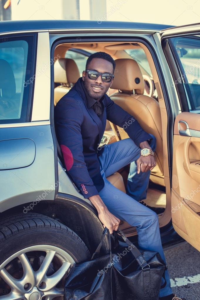 Young attractive man in smart casual outfit and sunglasses posing beside  elegant black car. Natural lighting, full body length, copy space Stock  Photo | Adobe Stock