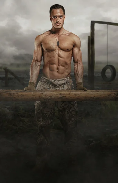 Shirtless soldier with wooden timber — Stock Photo, Image