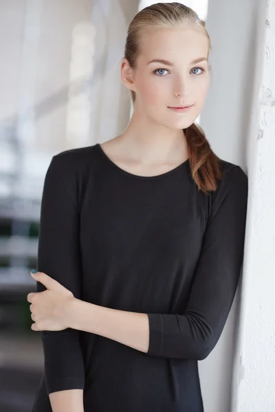 Blonďatá mladá žena v černých šatech — Stock fotografie