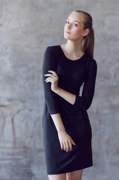 Blonde jonge vrouw in een zwarte jurk — Stockfoto