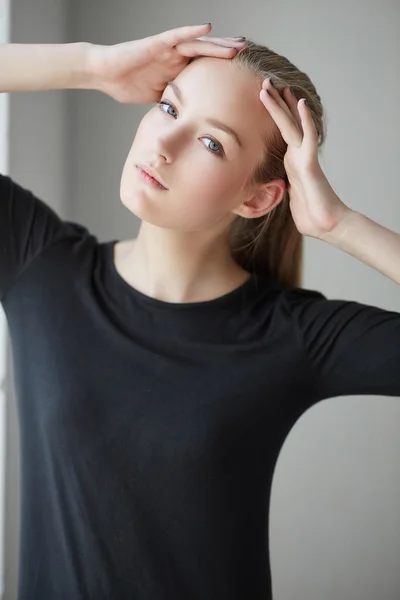 Blonde junge Frau in einem schwarzen Kleid — Stockfoto