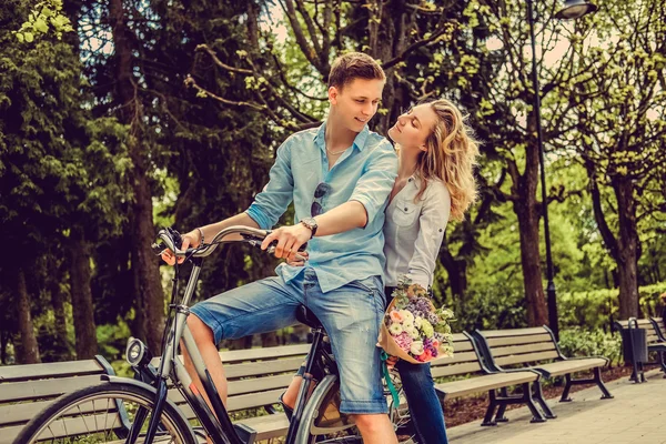 Joyfull par poserar på en cykel. — Stockfoto