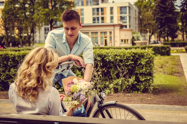 Hombre en una bicicleta da flores a su novia —  Fotos de Stock