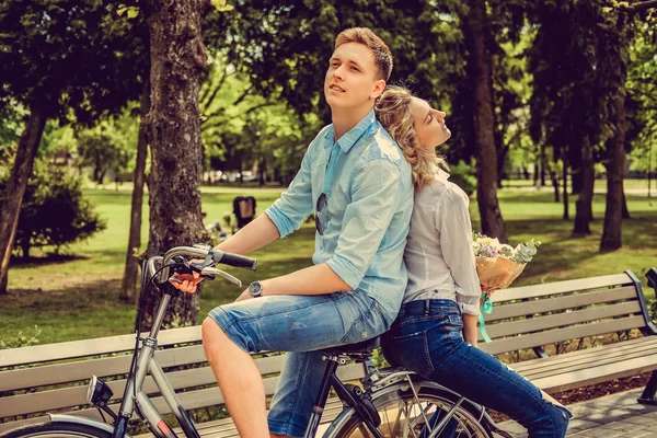 Joyfull par poserar på en cykel. — Stockfoto