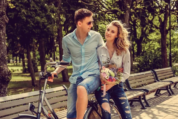 Joyfull paar poseren op een fiets. — Stockfoto