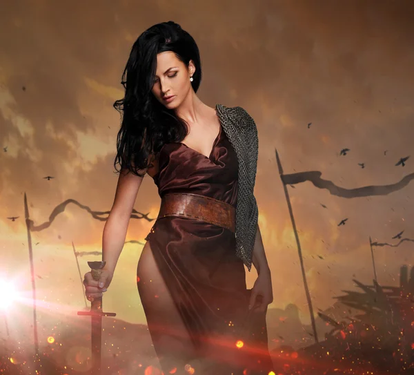 Sexy brunette female holding sword — Stock Photo, Image