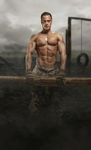 Shirtless soldier with wooden timber — Stock Photo, Image