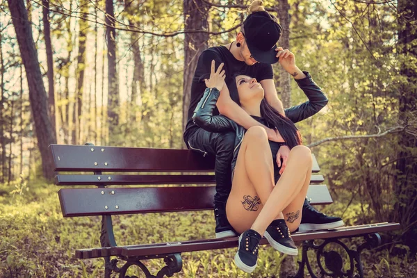 Jovem casal casual relaxante em um banco — Fotografia de Stock