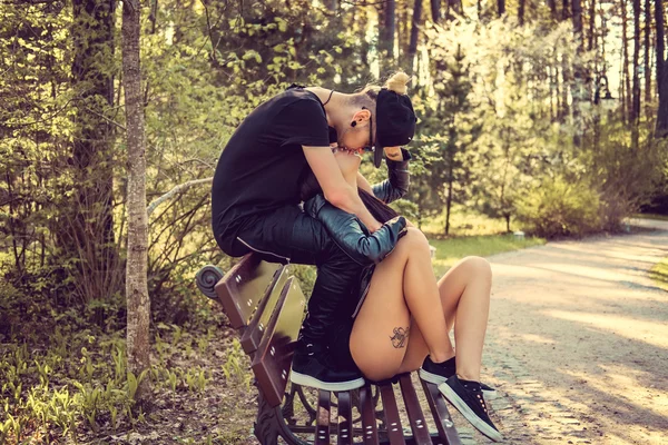 Jovem casal casual relaxante em um banco — Fotografia de Stock