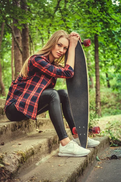 Feminino posando com longboard em escadas — Fotografia de Stock