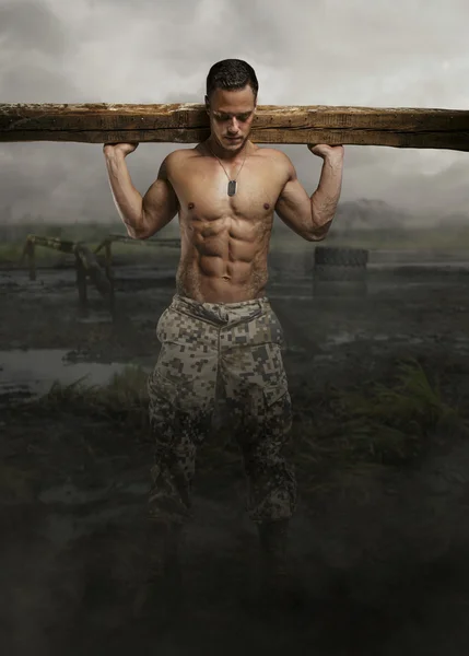 Shirtless soldier with wooden timber — Stock Photo, Image