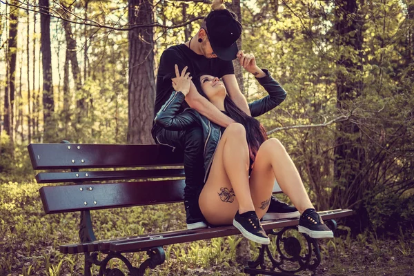 Молодая пара отдыхает на скамейке — стоковое фото
