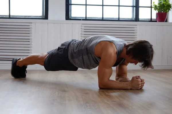 Homme faisant de l'exercice de l'estomac sur un plancher — Photo