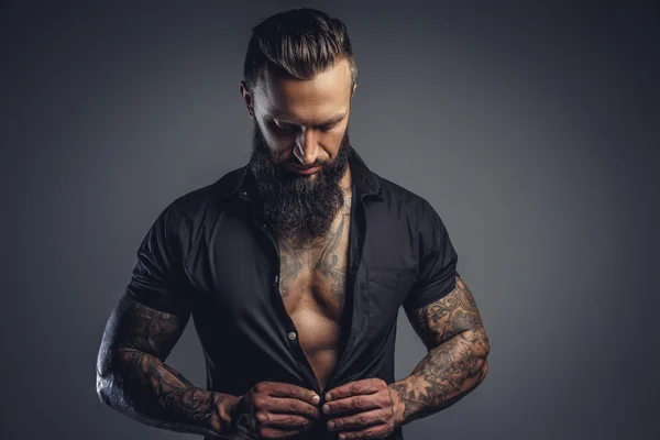 Tattooed male taking off his shirt — Stock Photo, Image