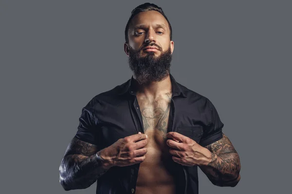 Татуированный мужчина в чёрной рубашке — стоковое фото