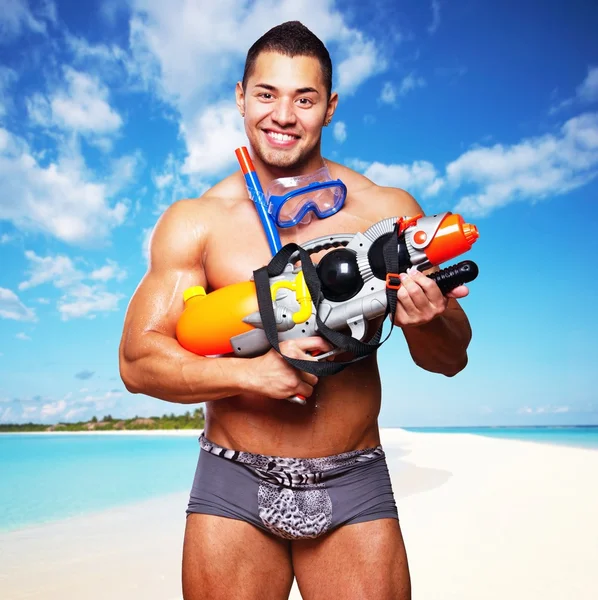 Muscular male with water gun — Stock Photo, Image