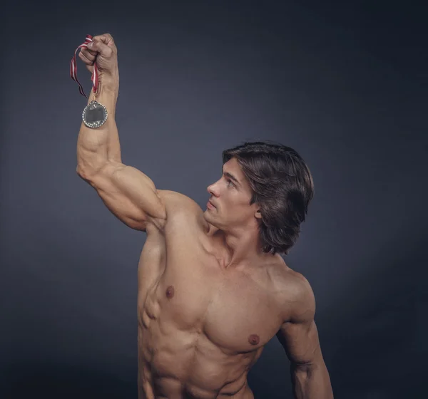 Muscular male holding silver medal — Stock Photo, Image