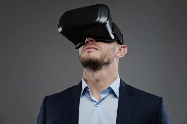 Masculino em um terno com óculos de realidade virtual — Fotografia de Stock