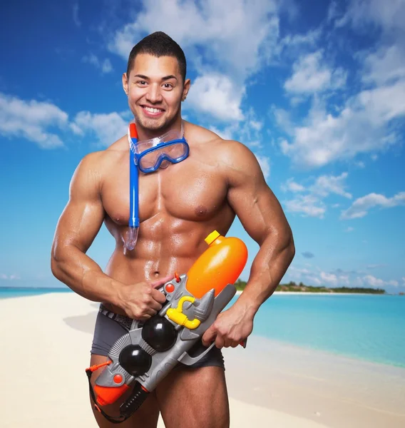 Muscular male holding water gun — Stock Photo, Image