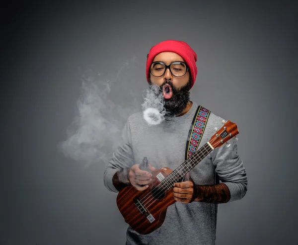 Masculino segurando guitarra e fumando um cigarro — Fotografia de Stock