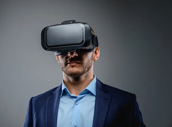 Masculino em um terno com óculos de realidade virtual — Fotografia de Stock
