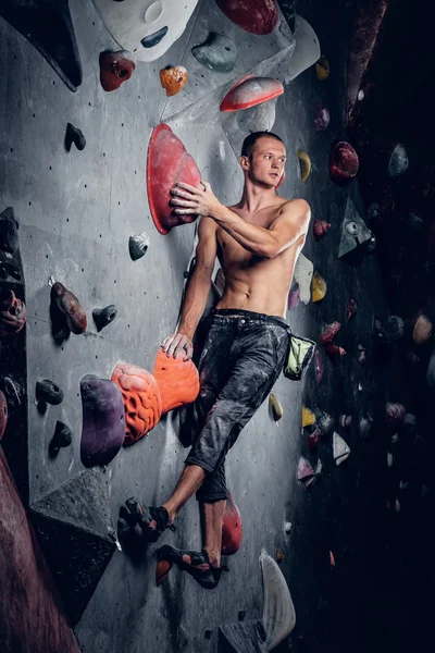 Hombre escalando en un muro de escalada interior — Foto de Stock