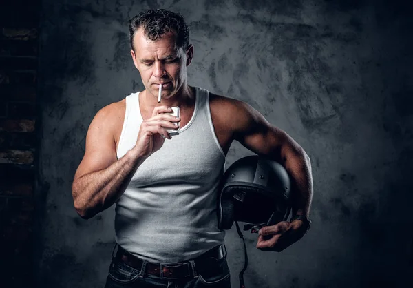 A man in a white t shirt smoking cigarette