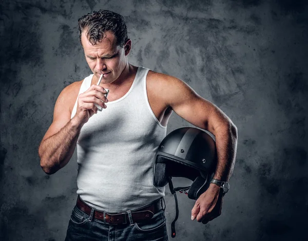 Un hombre con una camiseta blanca fumando cigarrillo — Foto de Stock