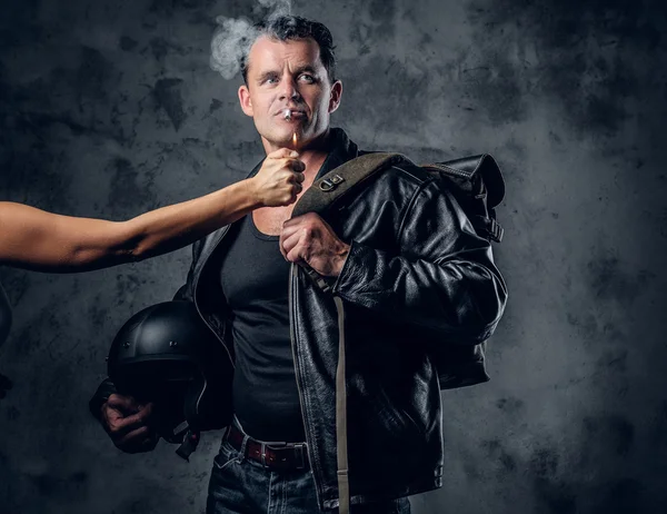 Un hombre enciende un cigarrillo del brazo de una mujer — Foto de Stock