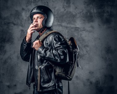 Bir sigara deri ceketli bir adamı