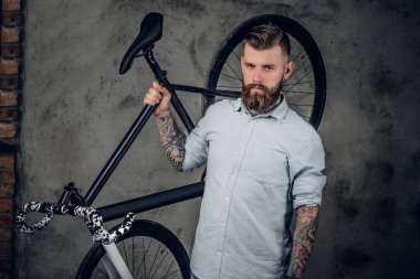Bir bisiklet tutan sakallı erkek
