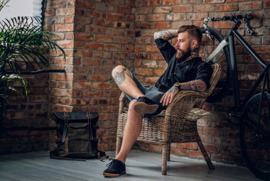 Erkek bir sandalyede oturuyor sakallı