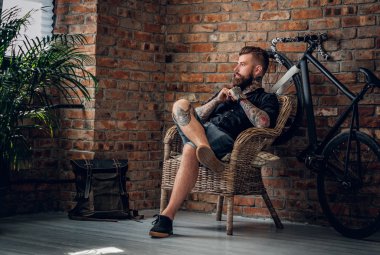 Erkek bir sandalyede oturuyor sakallı