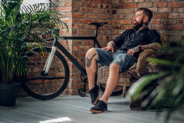 Erkek bir sandalyede oturuyor sakallı