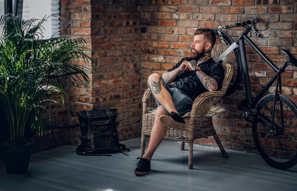 Бородатый мужчина, сидящий в кресле — стоковое фото