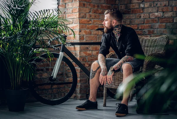 Gebaarde mannelijke zittend in een stoel — Stockfoto