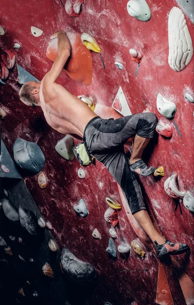 Escalada masculina en un muro de escalada interior — Foto de Stock