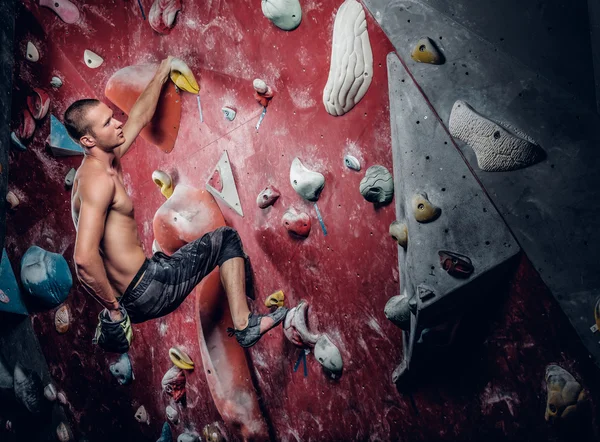 Escalada masculina en un muro de escalada interior — Foto de Stock
