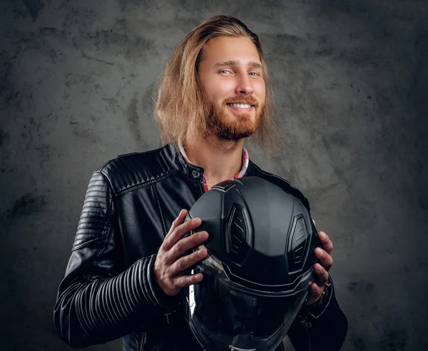 Redhead male holds motorcycle helmet