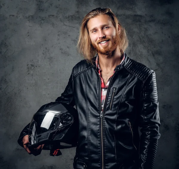 Redhead male holds motorcycle helmet