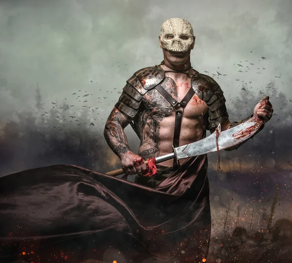 Männchen in Totenkopfmaske hält Schwert — Stockfoto