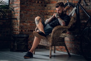 Düşünceli erkek bir sandalyede oturan dövme