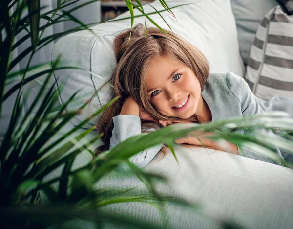 Chica sonriente posando en un sofá — Foto de Stock