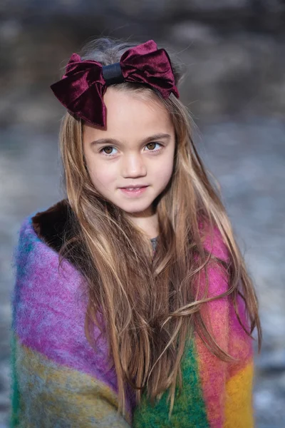Chica envuelta en una manta de colores cálidos — Foto de Stock