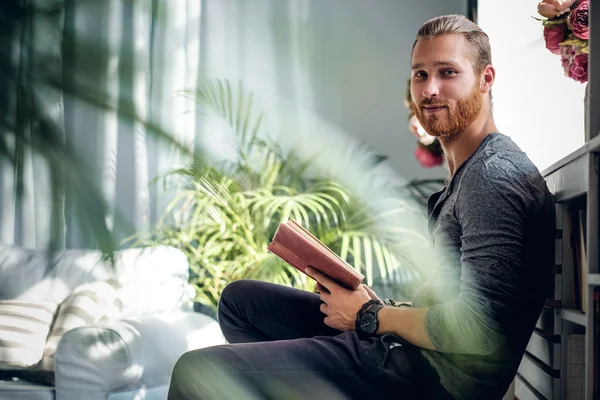 Redhead male holding a book