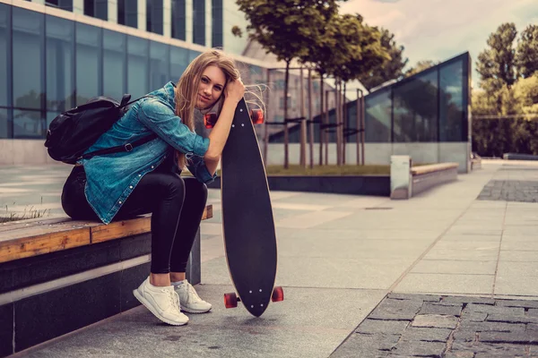 Casual blonde teef met longboard — Stockfoto