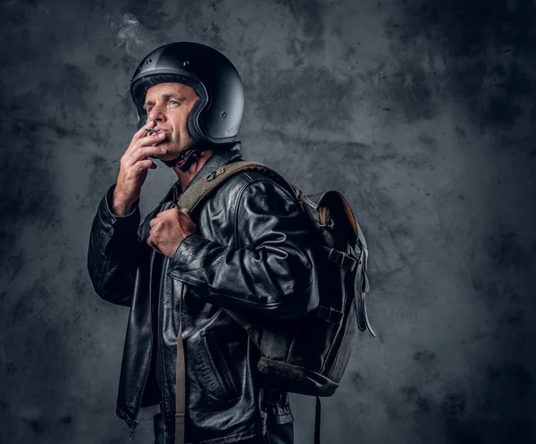 Homme en casque de moto fumant une cigarette — Photo