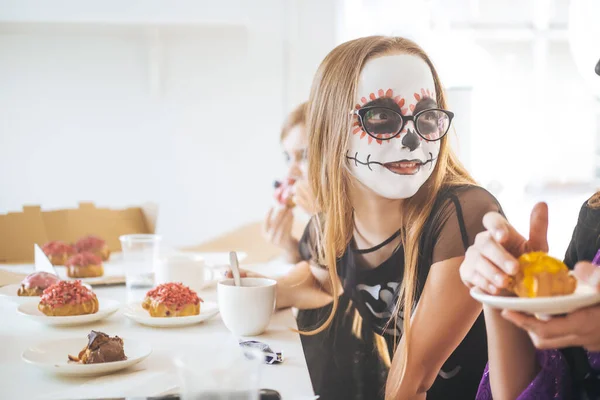 Vrolijke schoolmeisjes die snoep eten in de eetkamer — Stockfoto