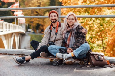 En iyi arkadaşlar paten kayıyor ve köprüde dinleniyorlar.